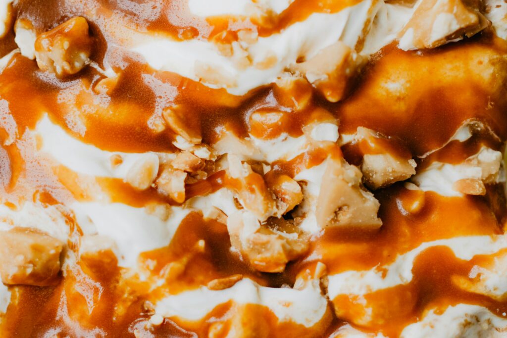 Rich vanilla ice cream topped with caramel sauce and crunchy nuts.